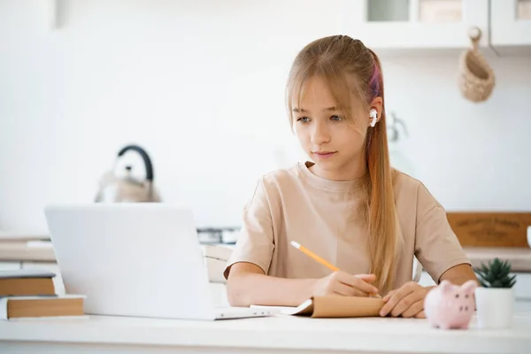 Chica joven usando el ordenador portátil para la tarea en casa —  Fotos de Stock