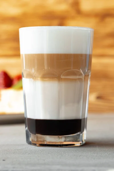 Glas av välsmakande aromatisk latte på trä bakgrund — Stockfoto