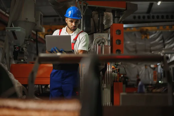 Ipari dolgozó laptoppal, kábelgyártó üzemben — Stock Fotó