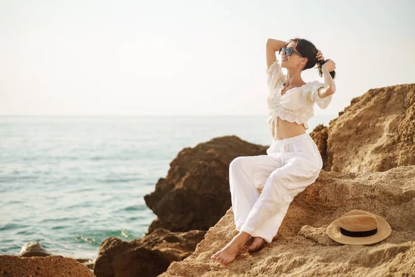 Frau Reisenden sitzt in der Nähe des Meeres auf Klippe genießen Blick auf das Meer und die Natur — Stockfoto