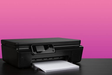 Pembe arkaplana karşı küçük ev lazer yazıcısı