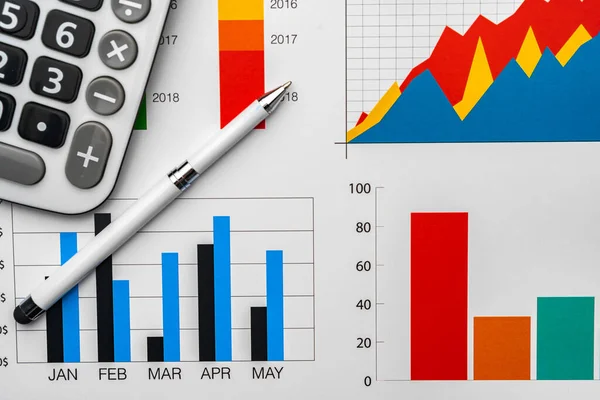 Gráficos de negócios papel e calculadora na tabela — Fotografia de Stock