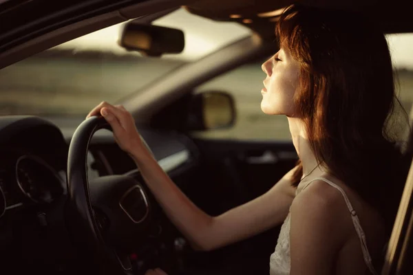 Schöne lächelnde Frau am Steuer ihres Autos am Morgen — Stockfoto