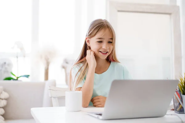 Niña feliz alumno usando el ordenador portátil en casa —  Fotos de Stock