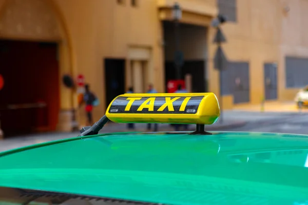 Panneau de taxi sur le toit d'une voiture dans une rue — Photo