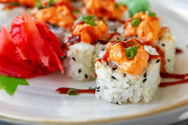 Japonské sushi se sezamovými semínky a smetanovou polevou na šedém pozadí — Stock fotografie