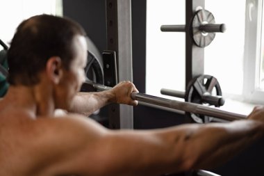 Vücut geliştiren bir adamın spor salonunda egzersiz yapması.