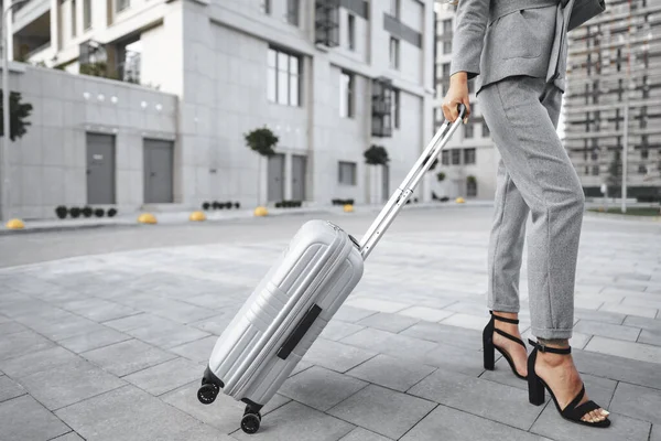 Geschäftsfrau im grauen Anzug auf Dienstreise mit Gepäck in der Stadt unterwegs — Stockfoto