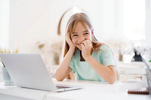 Niña feliz alumno usando el ordenador portátil en casa —  Fotos de Stock