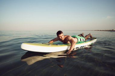 Genç formda adam gölde yüzüyor..