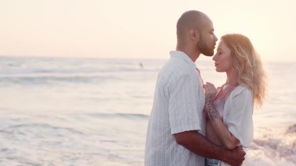 Jovem belo casal apaixonado de pé e abraçando na praia junto ao mar — Vídeo de Stock