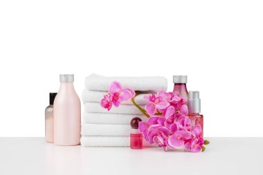 Beyaz üzerinde izole havlular ve çiçekler bulunan spa kompozisyonu