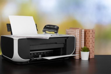 Masasında bulanık arkaplana karşı kitaplarla sıkıştırılmış ev yazıcısı