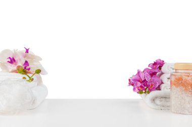 Beyaz üzerinde izole havlular ve çiçekler bulunan spa kompozisyonu
