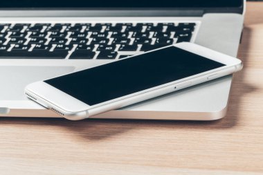 Dizüstü bilgisayar ve cep telefonu masada. Çalışma alanı kavramı.