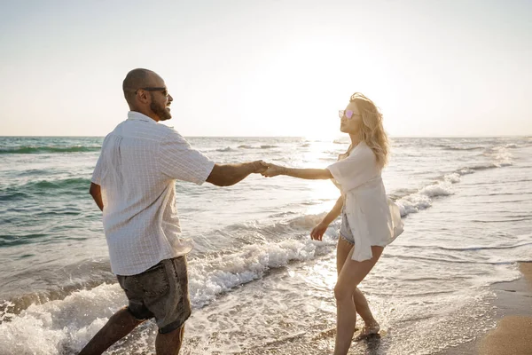 Jovem casal bonito andando na praia perto do mar — Fotografia de Stock