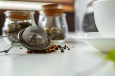 Kuru çay yapraklı cam kavanozlar beyaz masaya yakın.