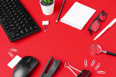 Kırmızı ofis masasında kırtasiye malzemeleri seti