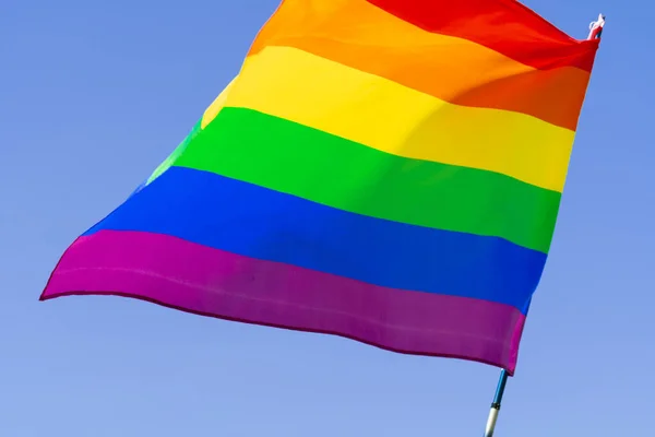 Gay arco iris bandera ondeando en el viento en un claro azul cielo —  Fotos de Stock