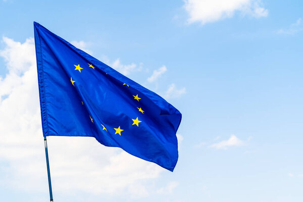 European Union flag against blue sky waving
