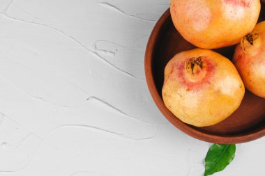 Açık gri mutfak masasında olgun nar.