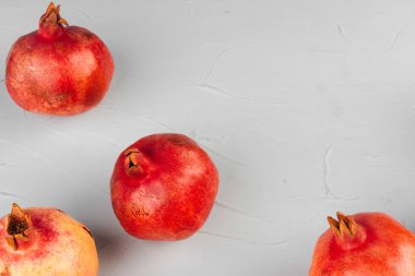 Açık gri mutfak masasında olgun nar.