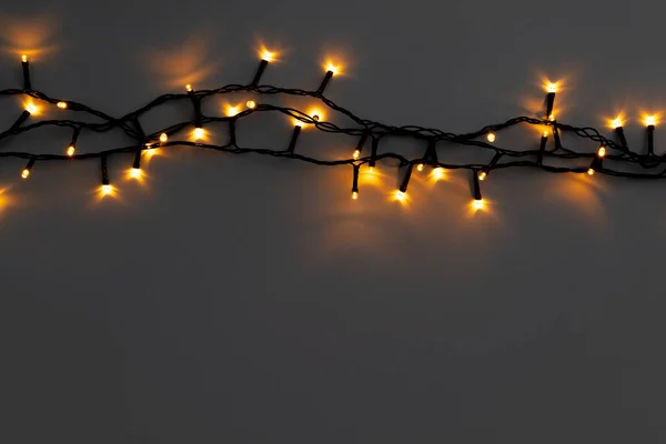 Guirlanda elétrica dourada brilhante em um fundo cinza — Fotografia de Stock