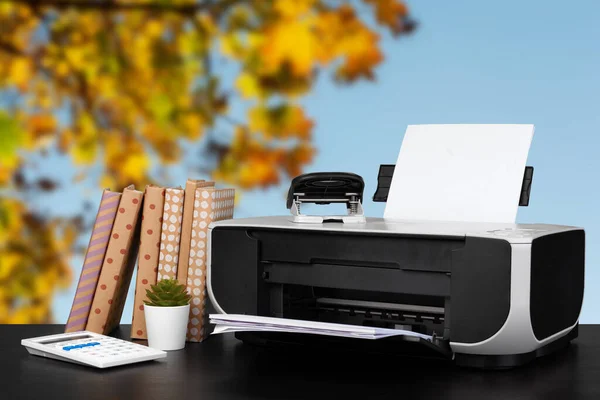 Impressora doméstica compacta na mesa com livros contra fundo desfocado — Fotografia de Stock