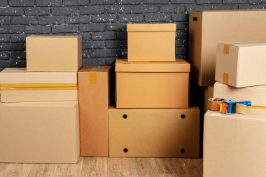 Kara tuğla duvara karşı boş odada yığınla karton kutu.