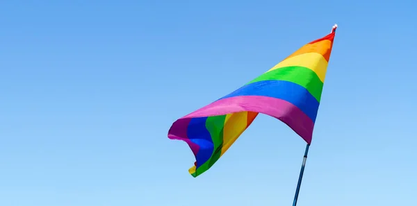 Gay arco iris bandera ondeando en el viento en un claro azul cielo —  Fotos de Stock