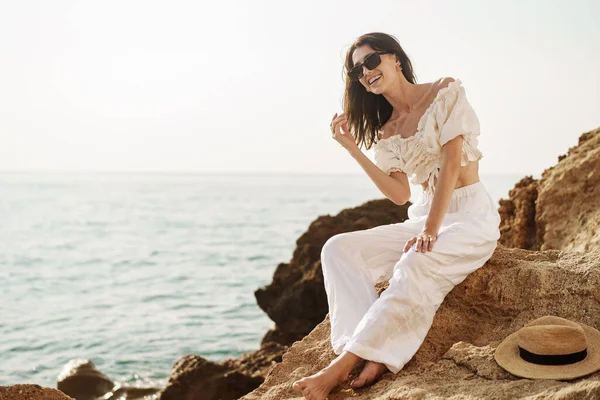 Frau Reisenden sitzt in der Nähe des Meeres auf Klippe genießen Blick auf das Meer und die Natur — Stockfoto