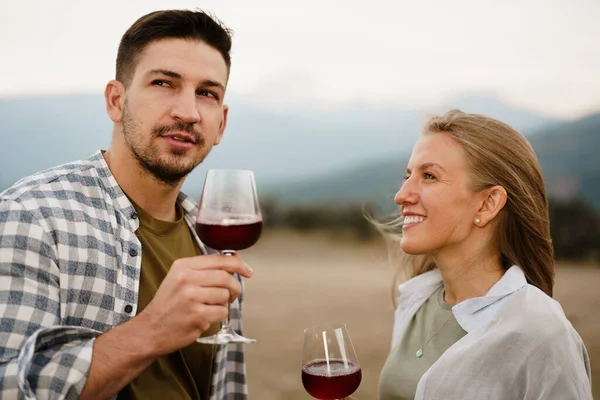 Sorrindo casal brindar copos de vinho ao ar livre em montanhas — Fotografia de Stock