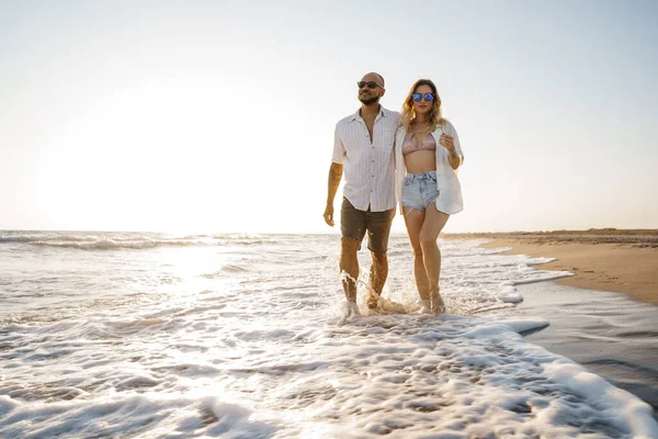 Jovem casal bonito andando na praia perto do mar — Fotografia de Stock