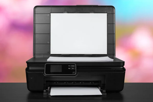 Kompakt laserskrivare på svart skrivbord mot suddig bakgrund — Stockfoto