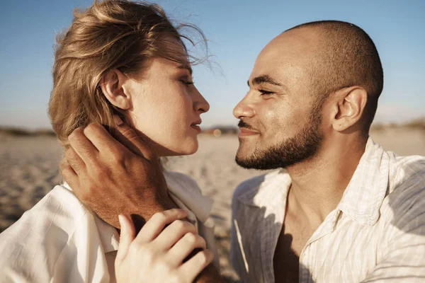 Retrato de feliz jovem casal apaixonado abraçando uns aos outros na praia — Fotografia de Stock