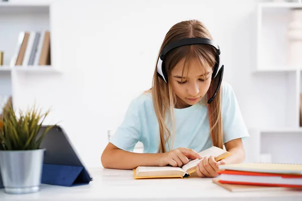 Little kaukaskie dziewczyna w słuchawki mają wideo rozmowy odległe klasy z nauczycielem w domu — Zdjęcie stockowe