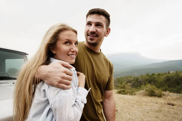 Jovem casal está em viagem romântica para as montanhas de carro — Fotografia de Stock