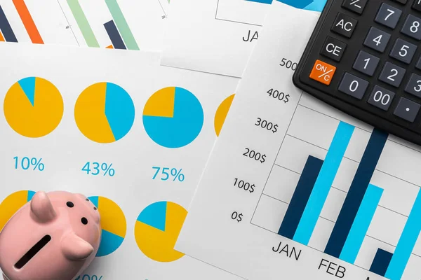 Business graphs paper and calculator on table — Stock Photo, Image