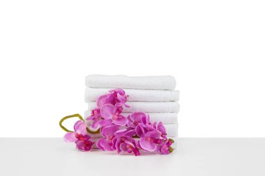 Beyaz üzerinde izole havlular ve çiçekler bulunan spa kompozisyonu