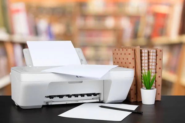 Impresora doméstica compacta en el escritorio con libros sobre fondo borroso — Foto de Stock