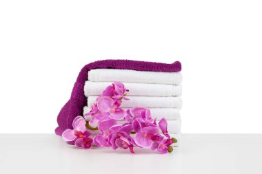 Beyaz üzerinde izole havlular ve çiçekler bulunan spa kompozisyonu