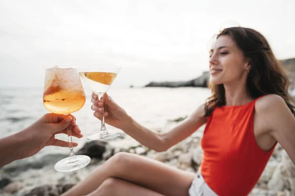 Retrato de uma jovem com um copo de cocktail a arrefecer numa praia — Fotografia de Stock