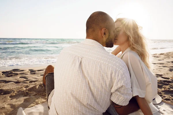 美丽的夫妻坐在海滩上观看日落 — 图库照片