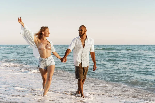 Jovem casal bonito andando na praia perto do mar — Fotografia de Stock