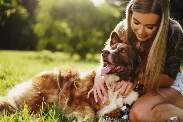 Young beautiful woman petting her cute dog in park — Stock Photo, Image