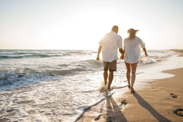 Junges schönes Paar zu Fuß am Strand in der Nähe des Meeres — Stockfoto