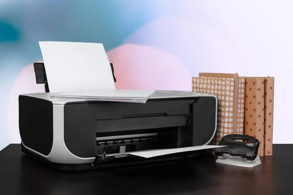 Компактний домашній принтер на столі з книгами на тлі розмитого фону — стокове фото