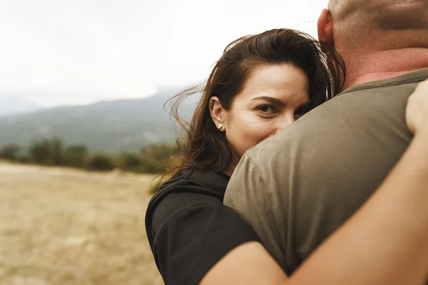 Lykkelig par som klemmer og smiler og har det gøy i fjellene – stockfoto