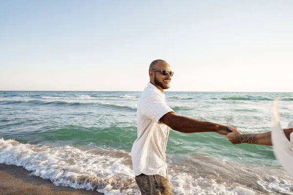 Jeune couple heureux au bord de la mer profitant de la mer — Photo