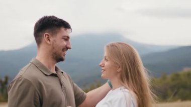 Genç ve sevgi dolu bir çift dağlarda durup sarılıyor. 